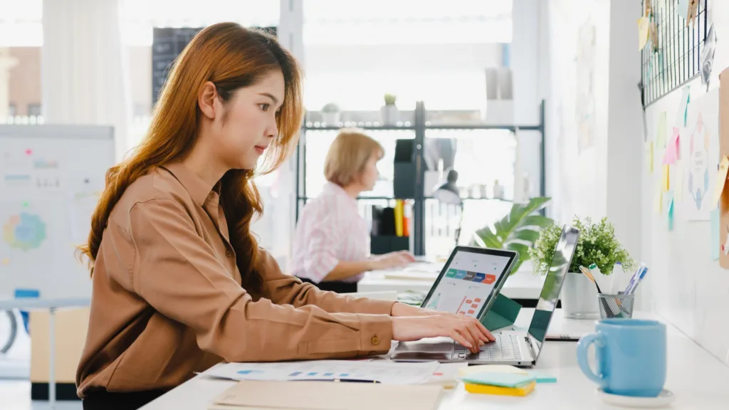 young-asia-businesswoman-entrepreneur-social-distancing-new-normal-situation-virus-prevention-while-using-laptop-computer-tablet-back-work-office (1)