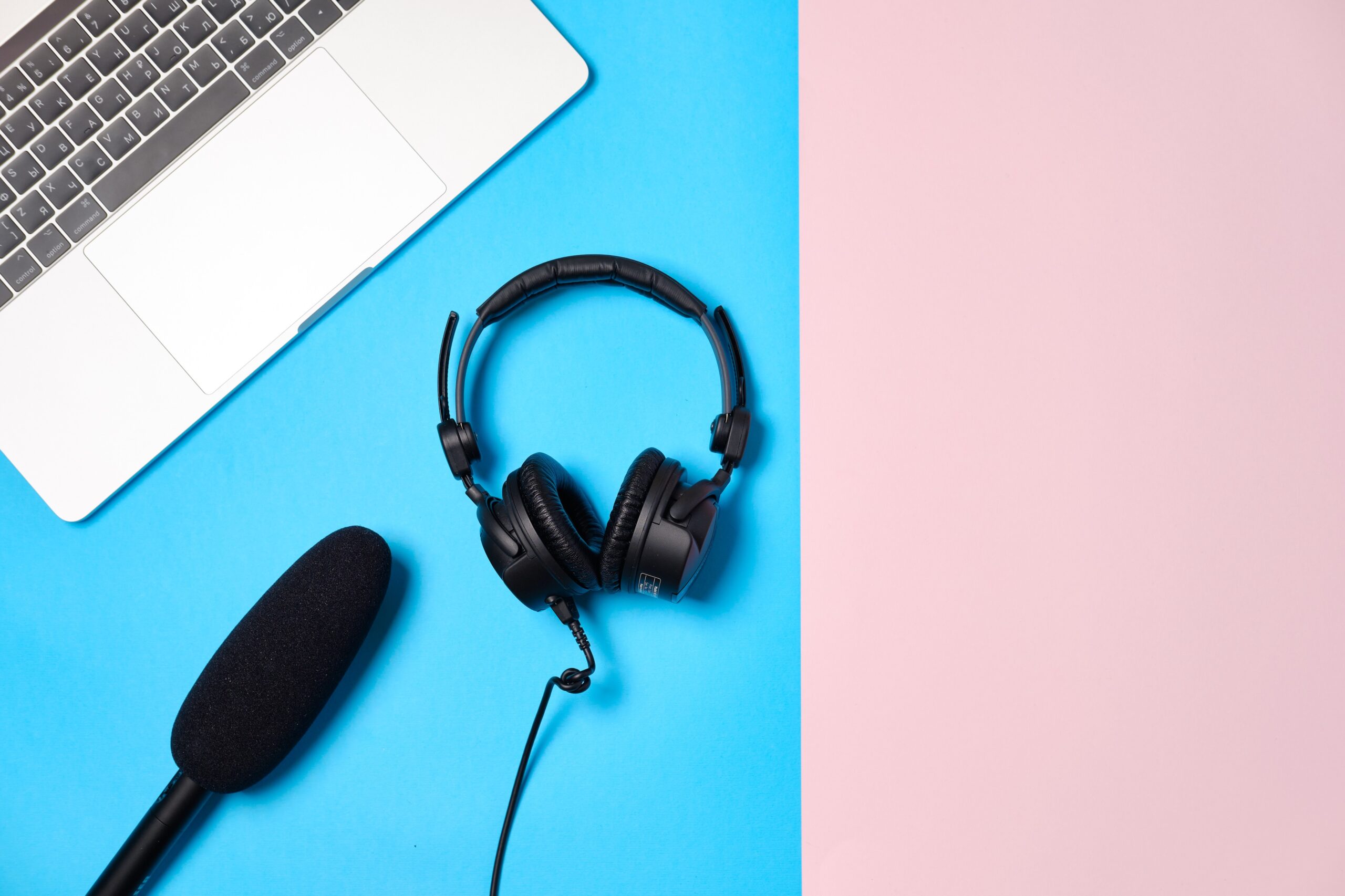 music-podcast-background-with-headphones-microphone-coffee-laptop-pink-table-flat-lay-top-view-flat-lay