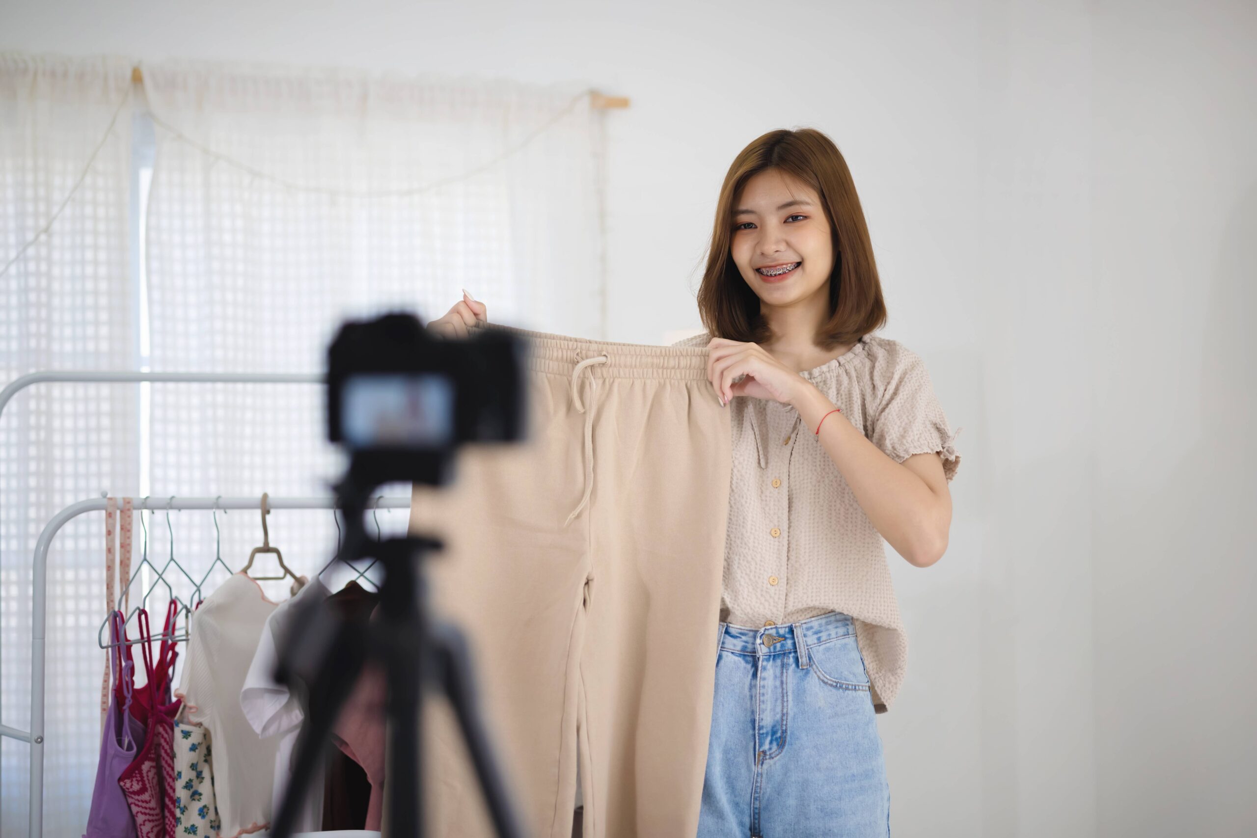 young-asian-seller-girl-showing-woman-clothes-making-video-live-streaming-online-home-online-market-with-social-media-concept 
