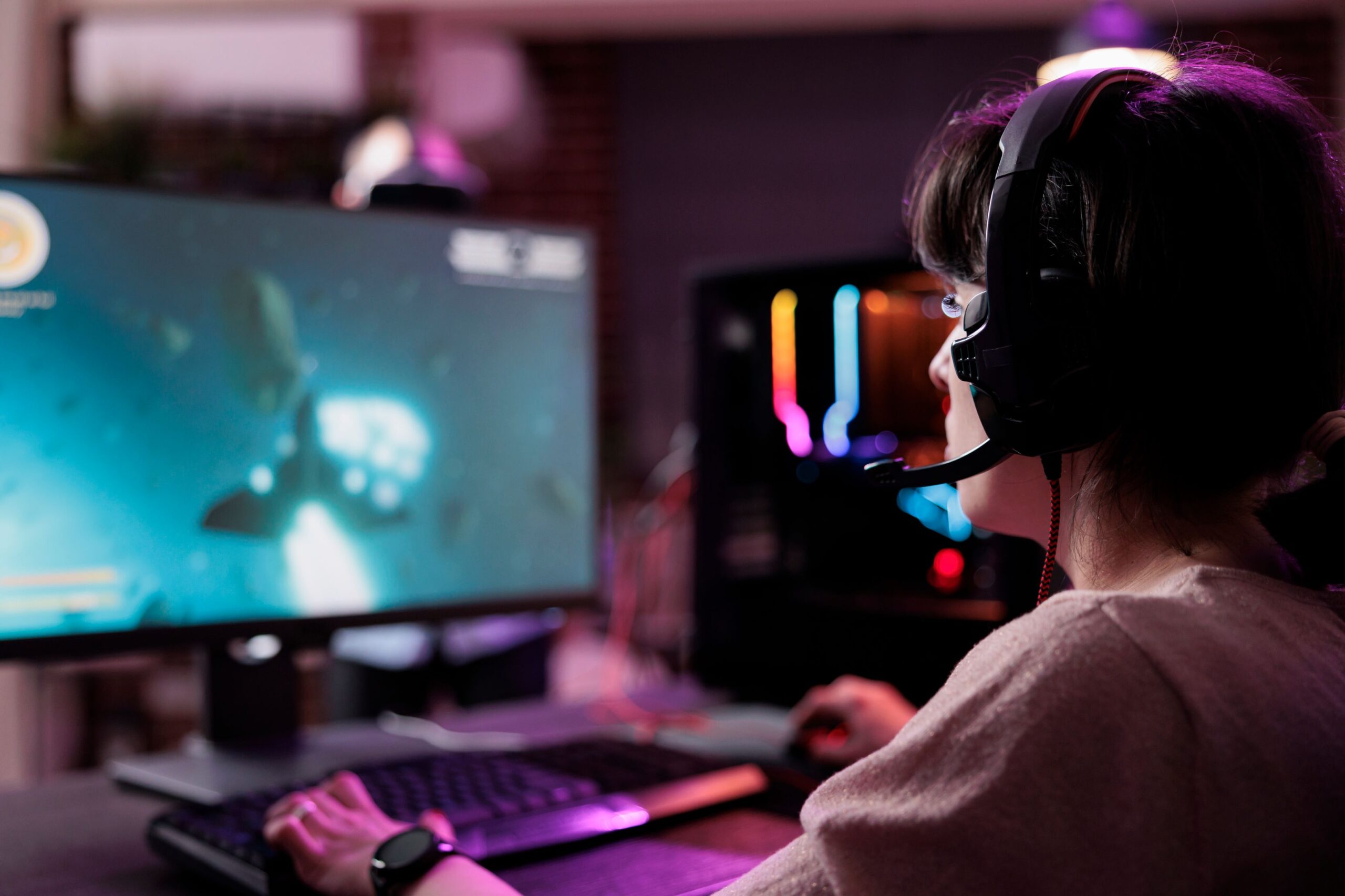 young-streamer-playing-video-games-online-live-stream-using-computer-neon-lights-living-room-female-gamer-having-fun-with-action-gameplay-virtual-shooting-tournament