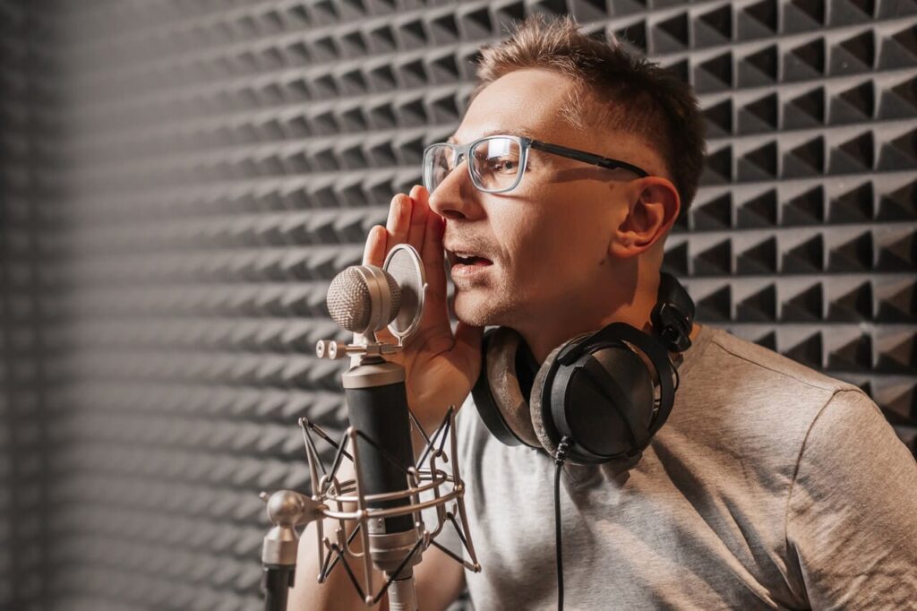 a man in headphones speaks something in a recording studio