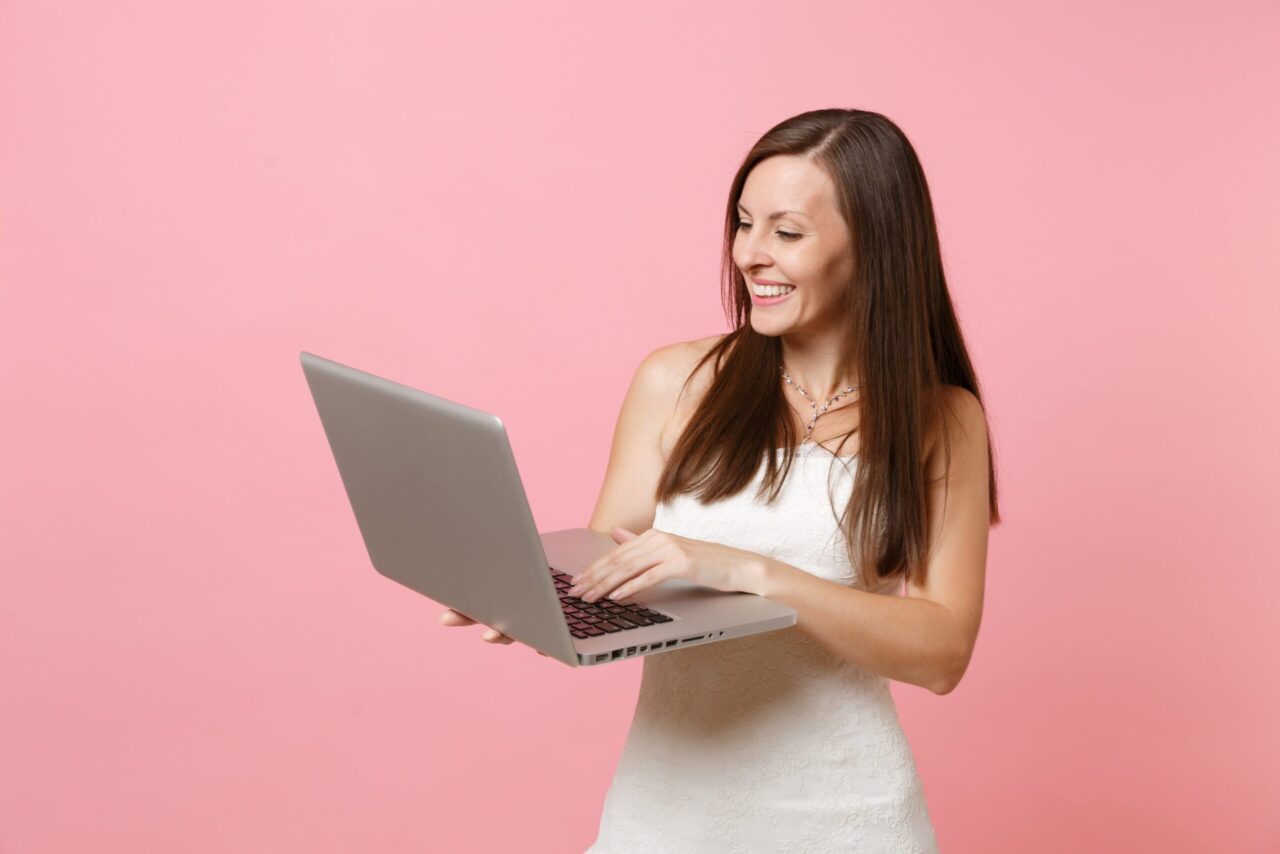 a smiling woman holding a laptop