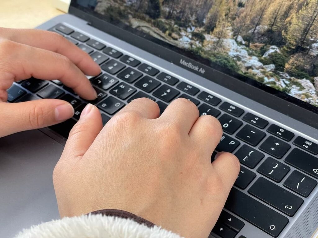 a person typing on a macbook air
