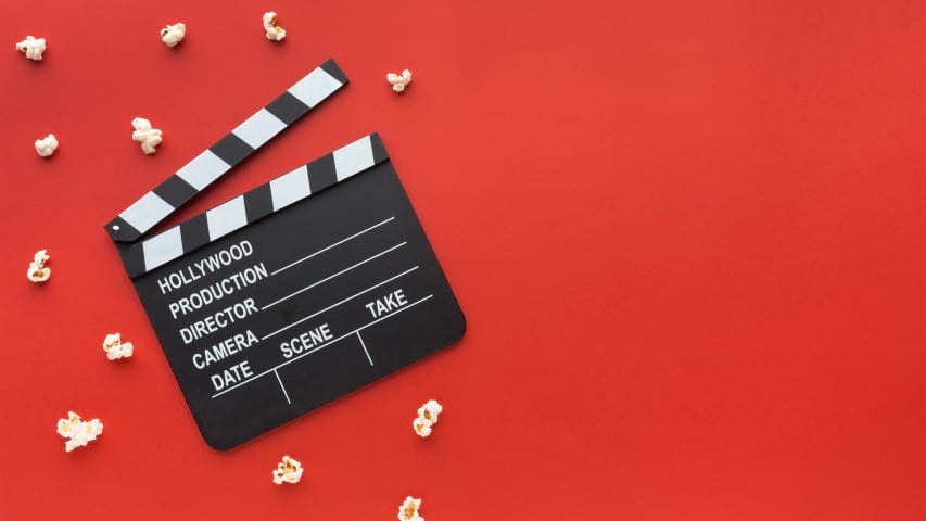 a movie slate with a red background and some popcorns