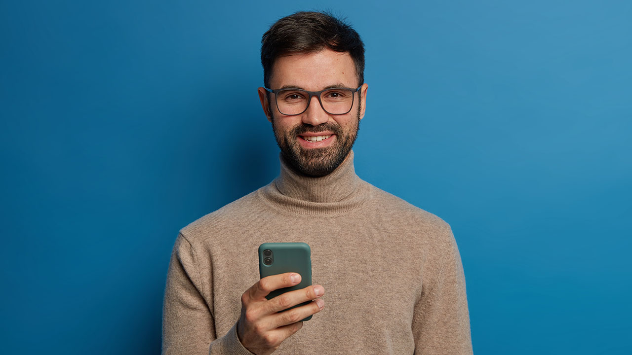 man using phone and smiling