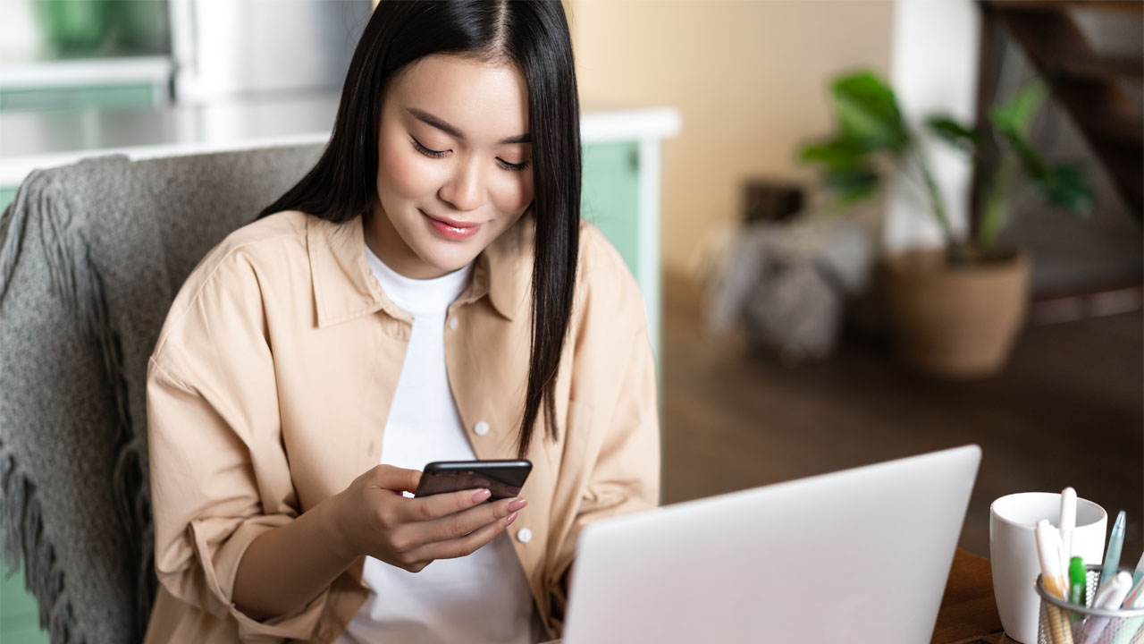 woman working with phone and laptop