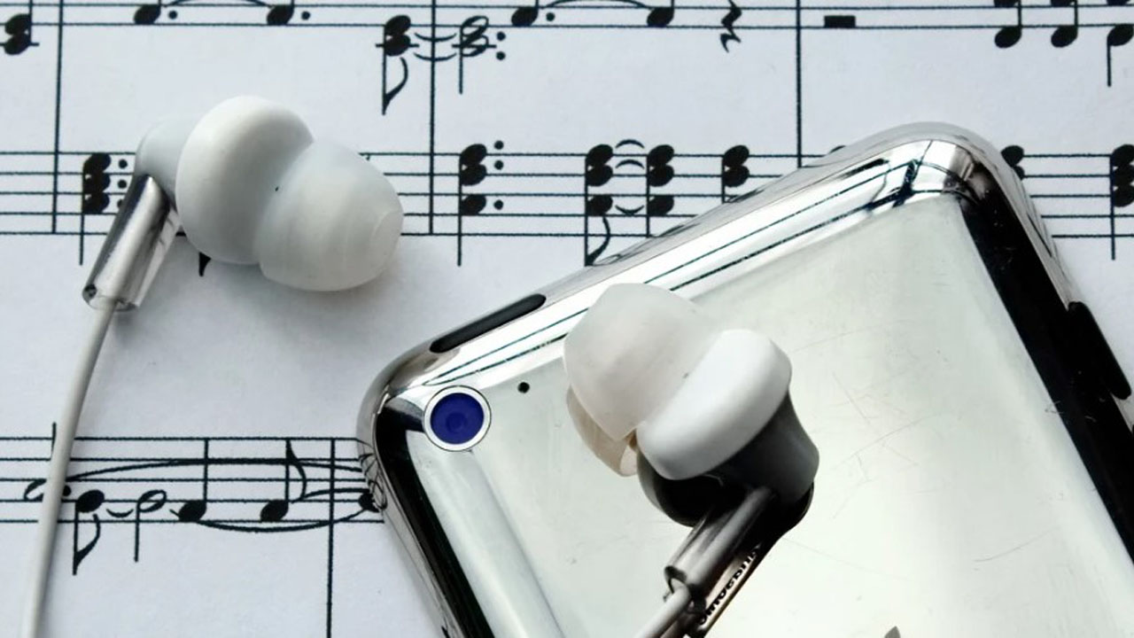 earphones and a mobile phone on a music sheet
