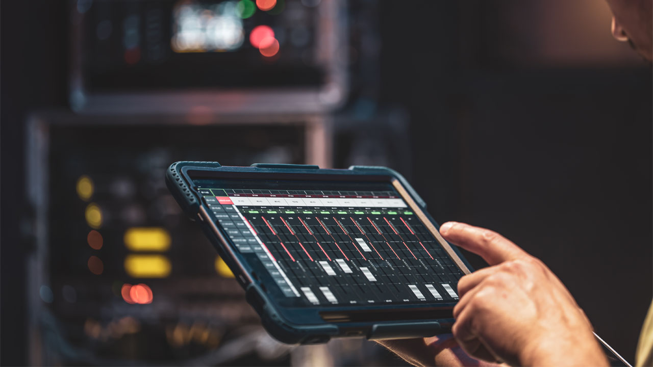 man operating audio controls on tablet