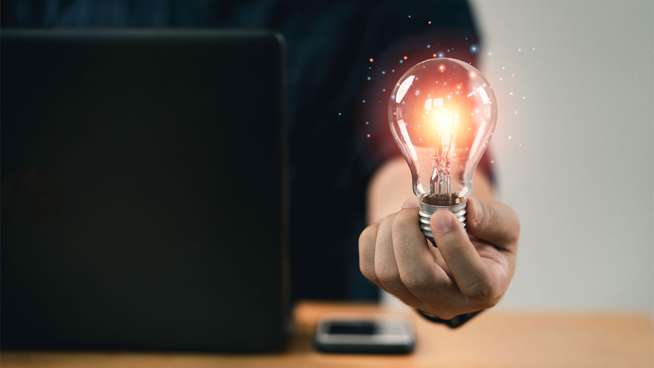 person holding a lightbulb that is turned on