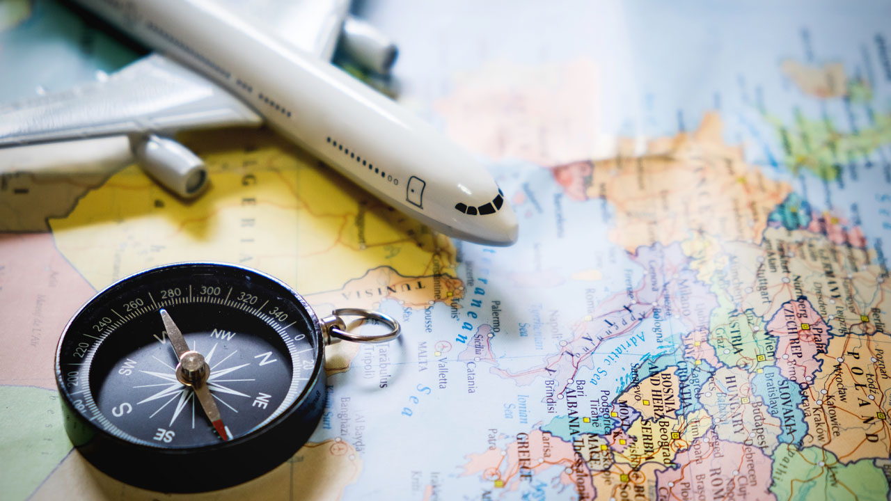 an airplane model and compass on a map