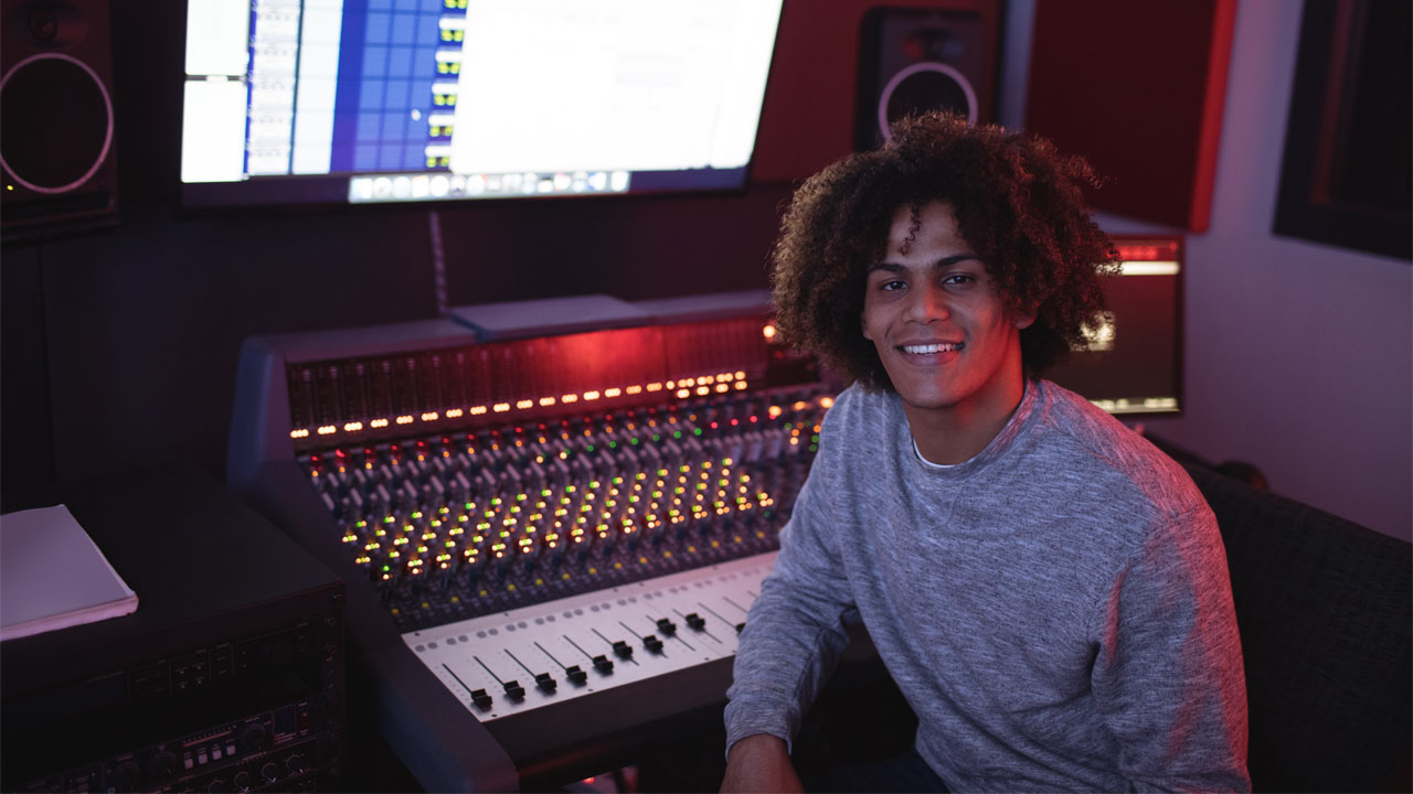 a music engineer sitting in front of his equipment set up