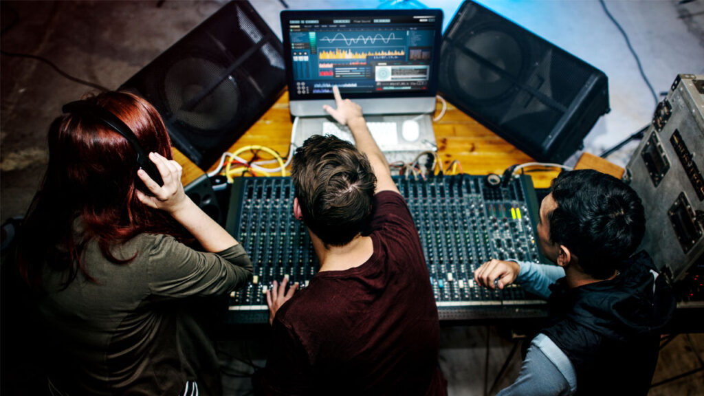 a group of people setting up a sound mixer station to create voice content