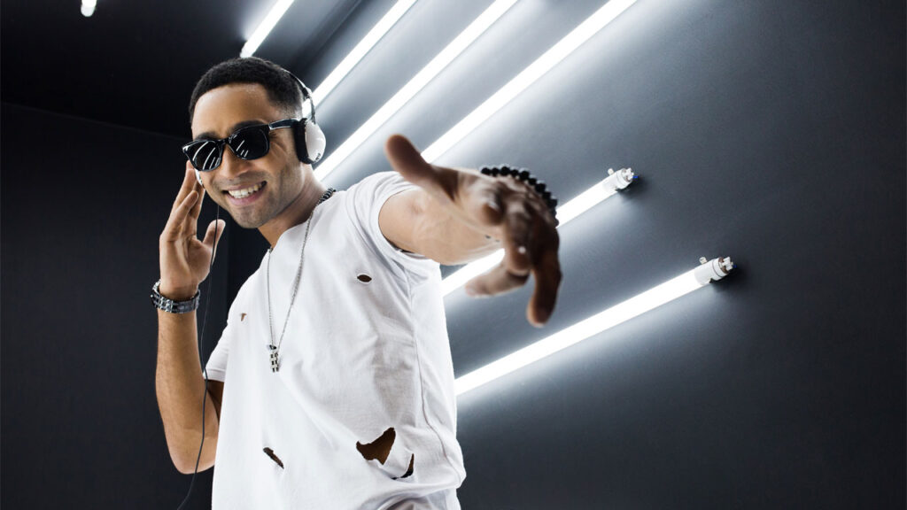 a male rapper in a white shirt and sunglasses listening to text-to-song and dancing