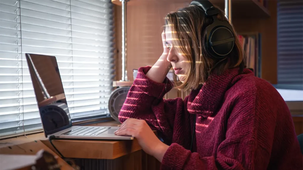 a woman troubleshooting some audio issues on her laptop