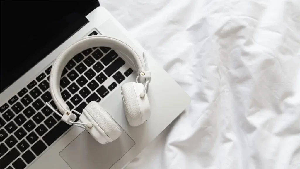 a pair of headphones resting on a macbook laptop