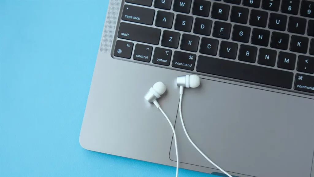 a paid of earphones resting on a macbook laptop