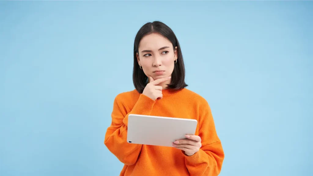 a woman thinking about something while using her tablet device