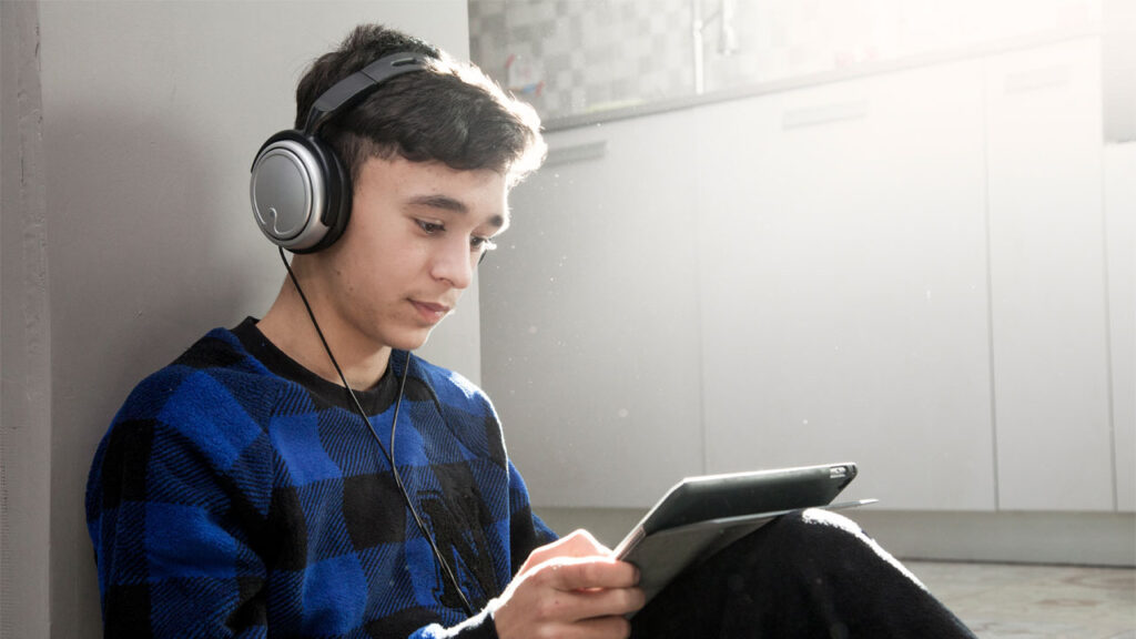 young man listening to his tablet with headphones
