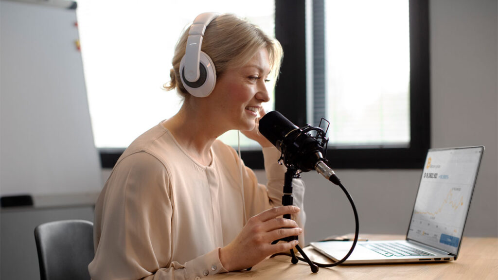 a female voice actor recording audio on her laptop