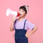 a young girl speaking on a megaphone