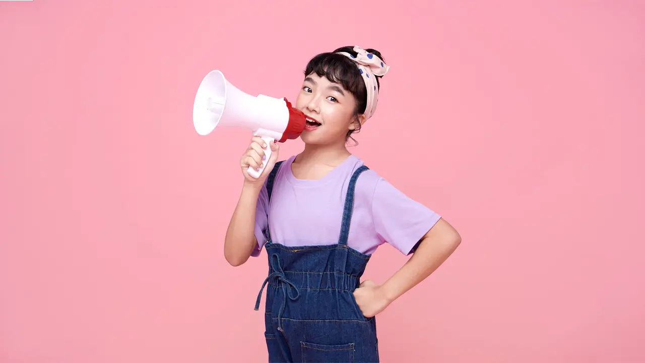 a young girl speaking on a megaphone