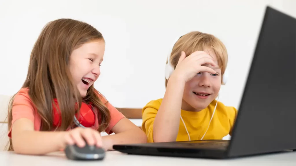 two kids enjoying listening to text to speech voices on their laptop