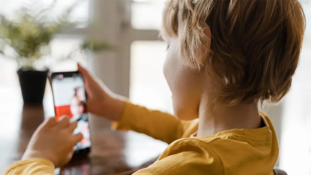 Kid scrolling through phone.