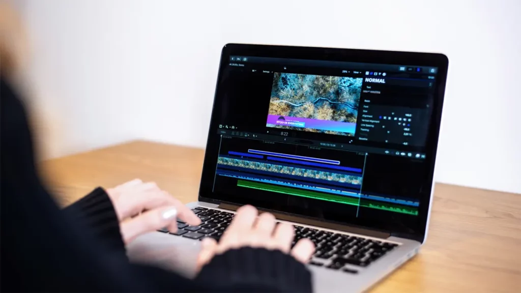 A woman using a video editing program on her laptop.
