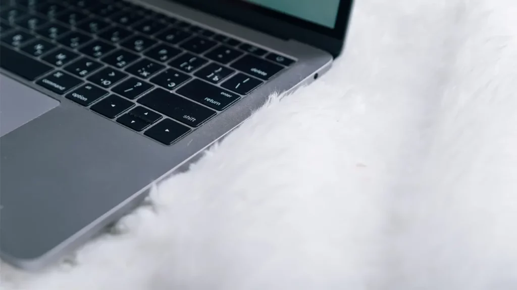 Close-up of a MacBook on the floor.