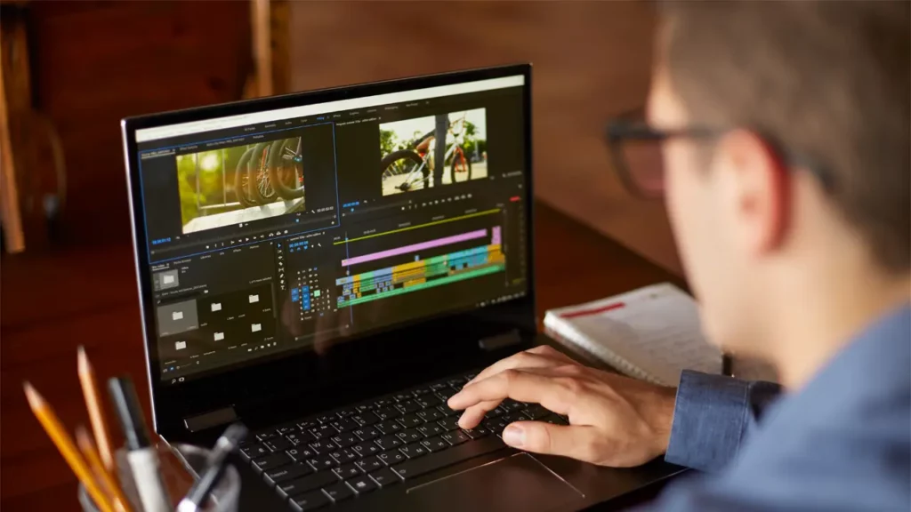 A man editing videos on his Windows laptop.