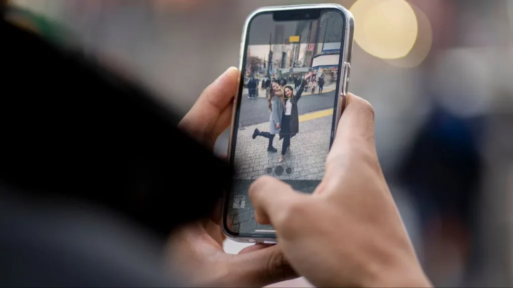 Person taking a photo with a phone in a city.