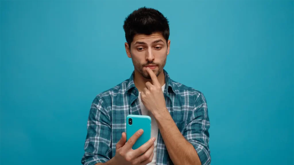A man using his smart phone and thinking.