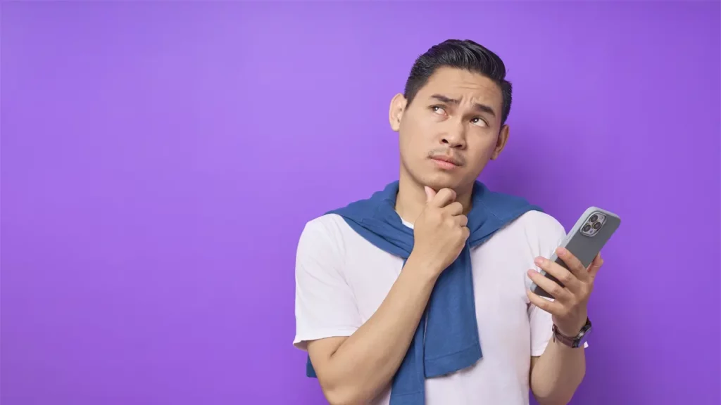 A man holding a phone and thinking.