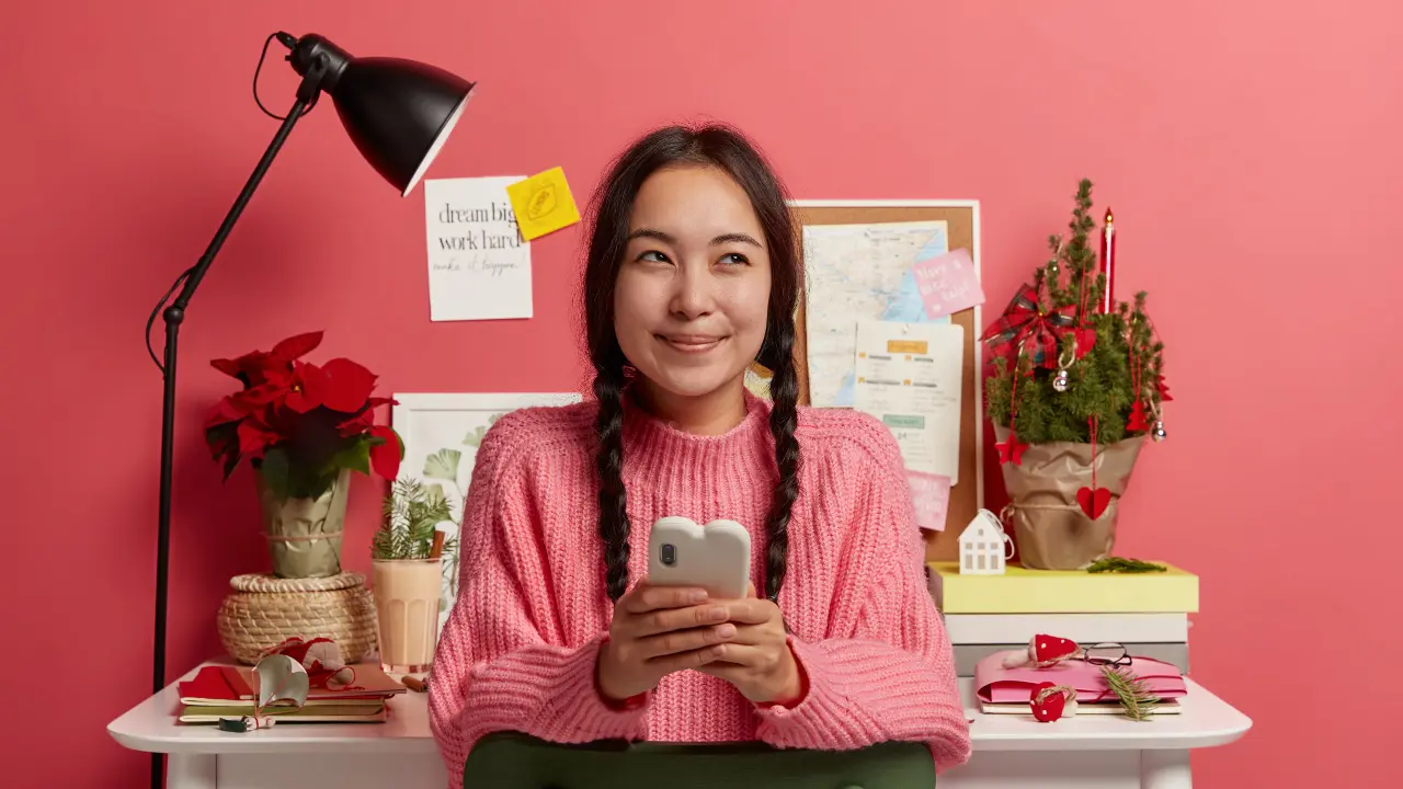 A young woman smiling with a phone.