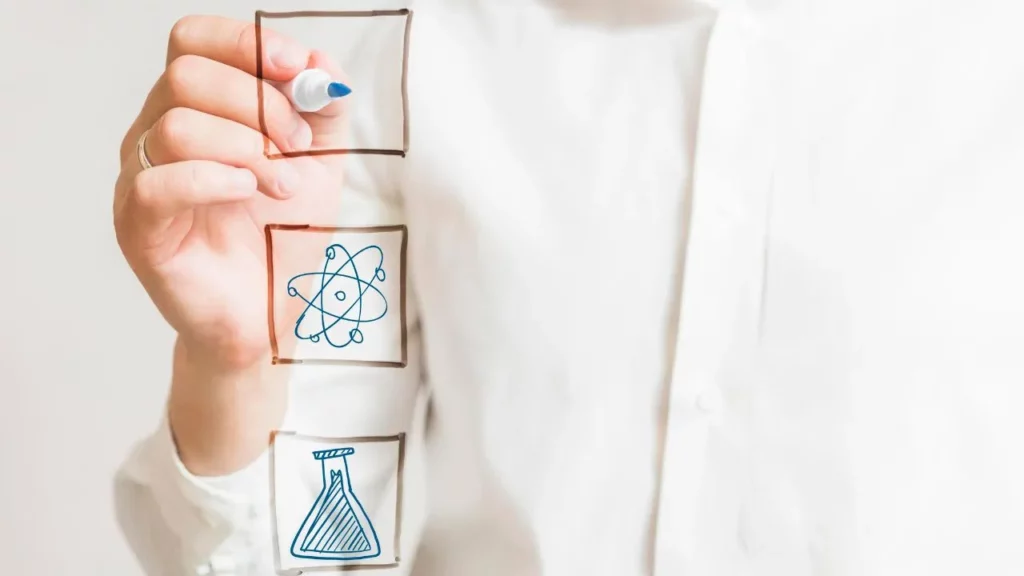 Hand drawing checkboxes with science icons on a shirt.