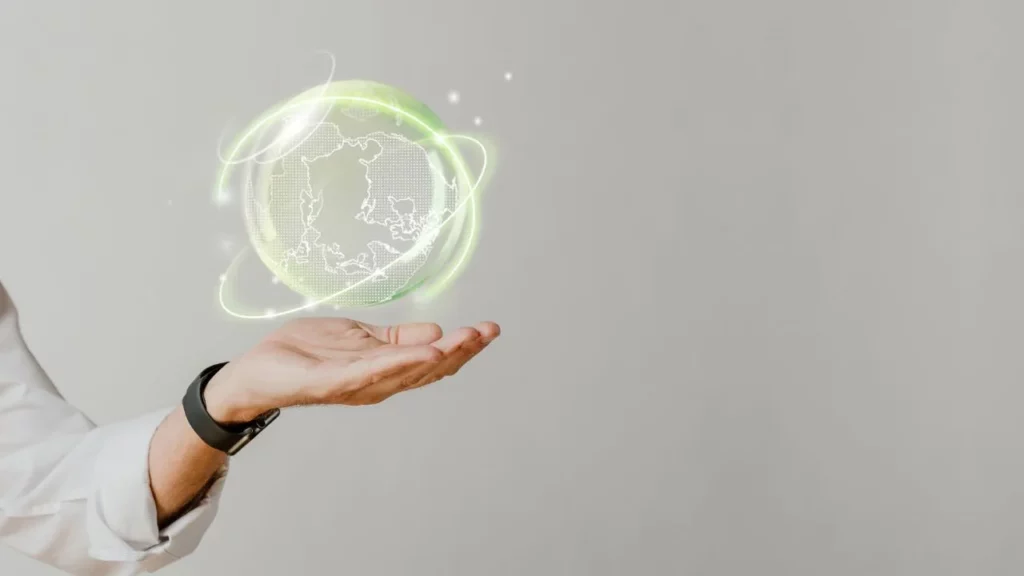 Hand holding glowing holographic globe with orbiting rings.