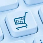 Close-up of a computer keyboard with a shopping cart icon on the enter key.