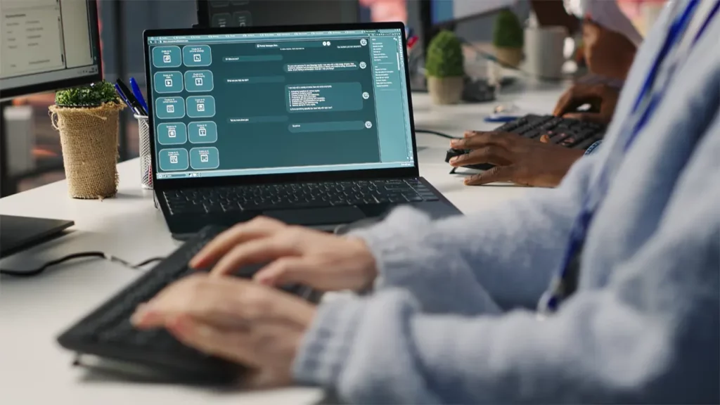 A person working on their laptop and PC.