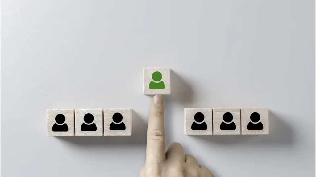 A person choosing a wooden block with a green person on it.