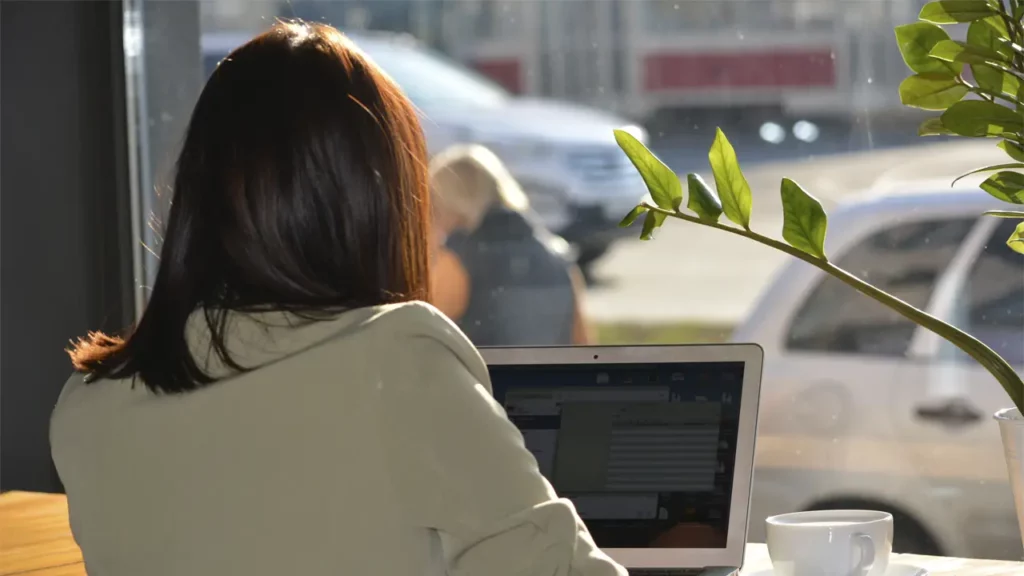 A woman working on her laptop in a cafe.