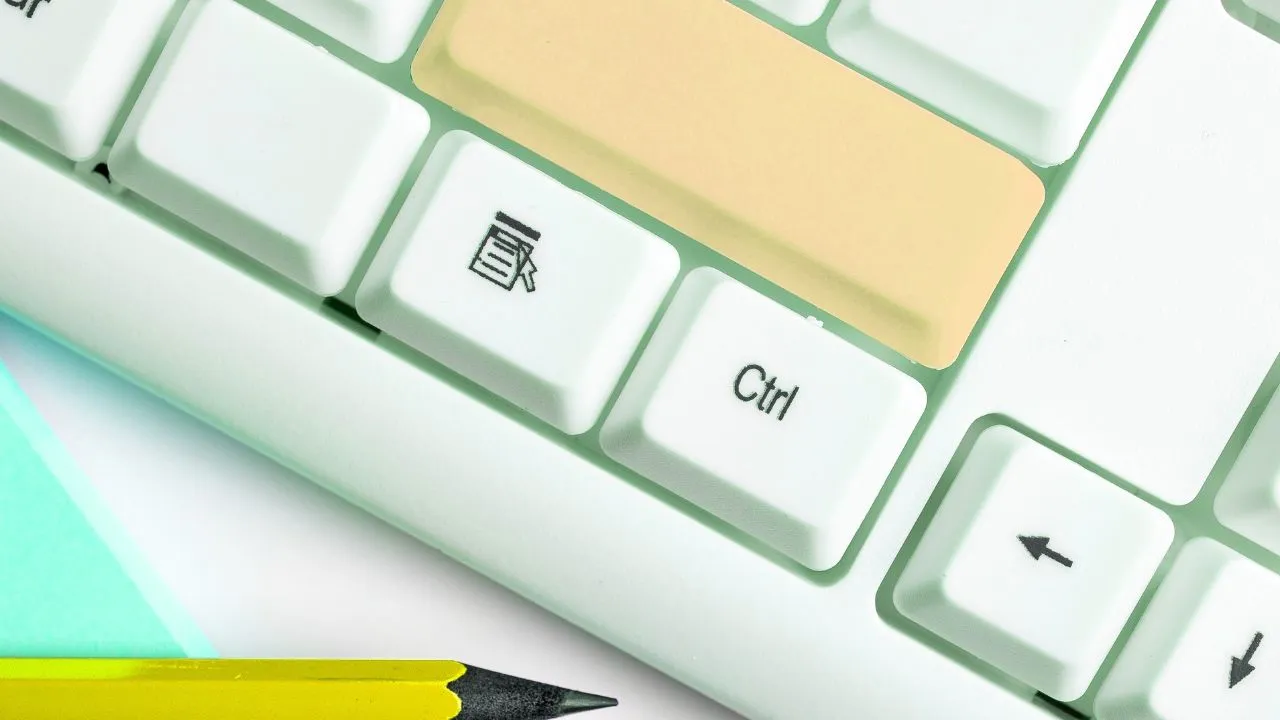 Macro shot of a white computer keyboard with the Enter/Return key highlighted in beige.