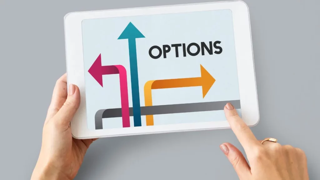 A person holding a white tablet displaying a graphic with the word "OPTIONS" in bold, accompanied by three colorful diverging arrows (pink left, teal up, orange right) on a light blue background, representing choices or decision-making.