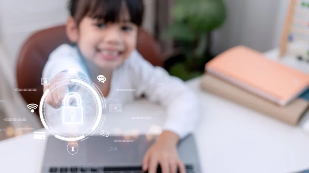 A young child smiling and touching a digital security lock icon on a laptop.