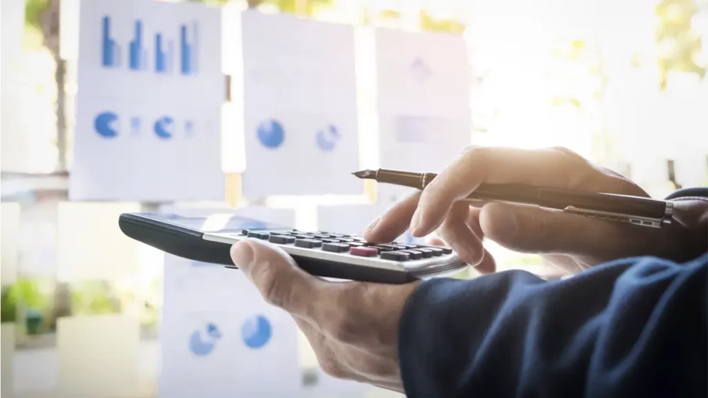 A person calculating costs on a calculator.