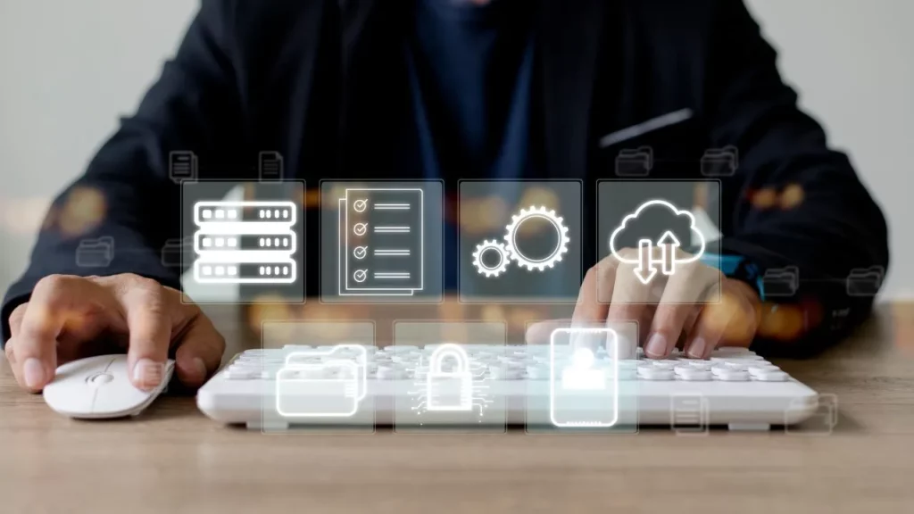 A person using a computer keyboard and mouse with glowing digital icons floating above, representing data storage, checklists, settings, cloud syncing, and security.