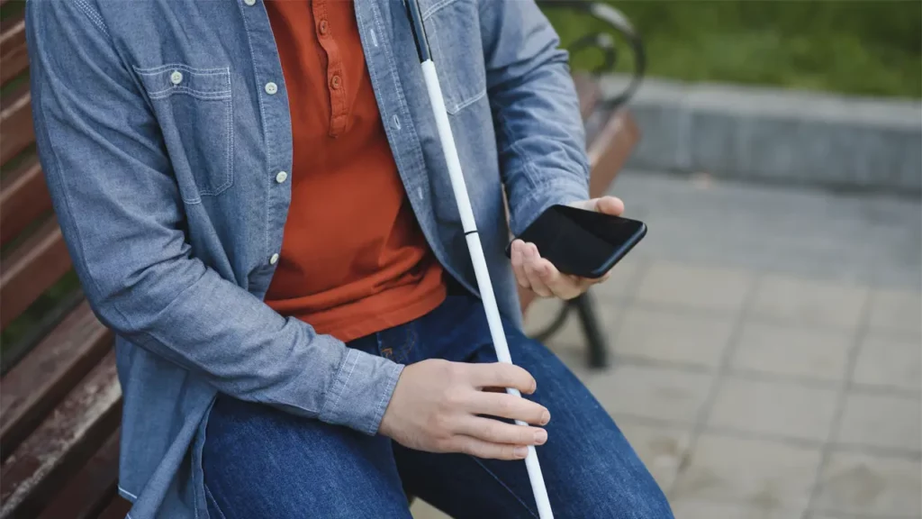 A bling man using TTS accessibility features on their mobile.