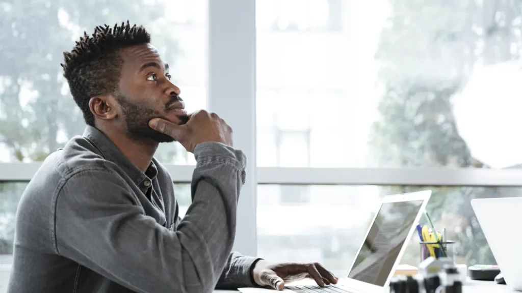 A man thinking at his laptop.